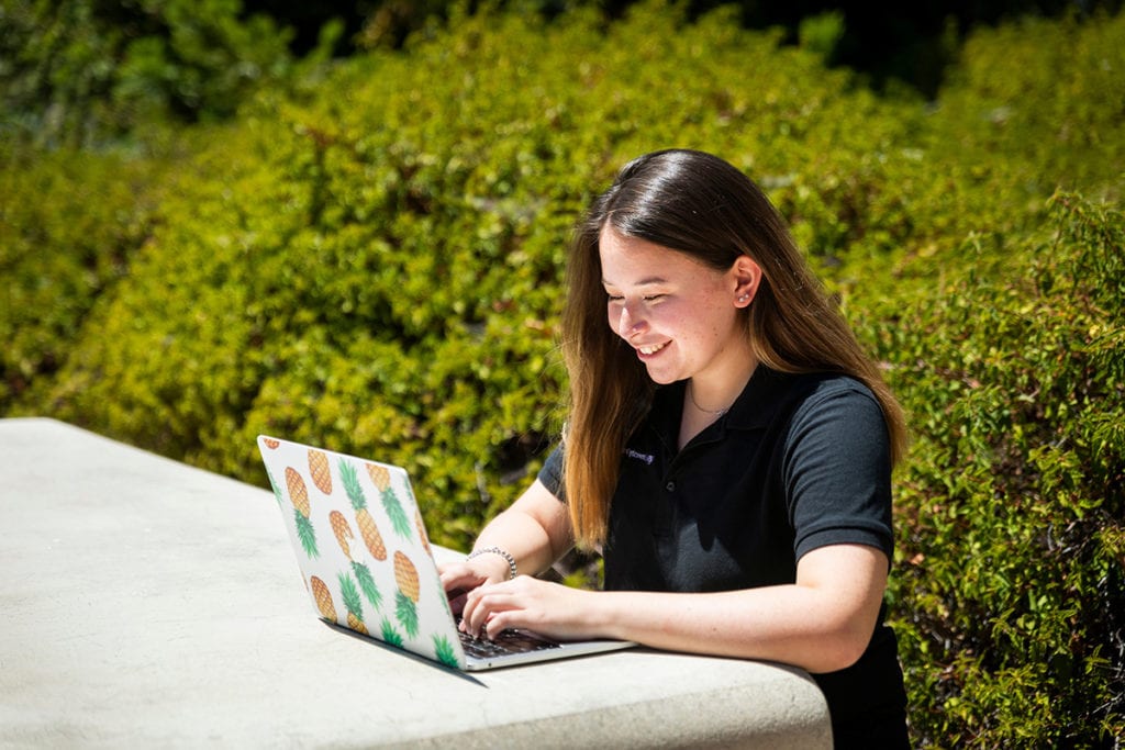 Cal Poly student working outdoors on laptop