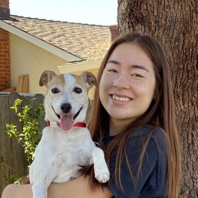 Portrait of Ally Lai smiling and holding pet dog